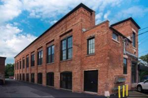 un edificio de ladrillo rojo con ventanas en una calle en Modern Loft Style on Monroe by Dwtn & Park ave, en Rochester