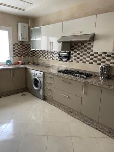 uma cozinha com uma máquina de lavar roupa e uma máquina de lavar roupa em Ryad zitoune em Meknès
