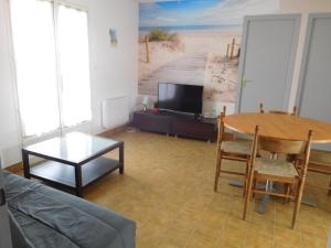 Televízia a/alebo spoločenská miestnosť v ubytovaní Maison au calme avec jardin, proche plage et commerces, équipée pour famille de 6 personnes - FR-1-476-197