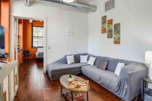 a living room with a couch and a table at NY Style Centric Loft with King Bed by Park av in Rochester