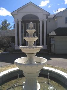 a white fountain in front of a house at Conservation lands family suite 2 rooms in Tottenham
