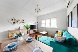Una sala de estar con un sofá azul y una mesa. en Art Deco Hideaway - St Kilda, en Melbourne