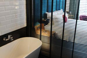 a bath tub in a bathroom with a window at WEIL Hotel Ipoh in Ipoh