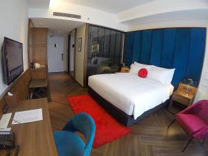 ein Hotelzimmer mit einem Bett, einem Schreibtisch und Stühlen in der Unterkunft WEIL Hotel Ipoh in Ipoh