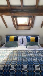 a bedroom with a bed with a blue and yellow quilt at Hay On Wye Welsh Townhouse in Hay centre in Hay-on-Wye