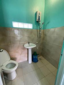 a bathroom with a toilet and a sink at Medano Sunset Resort in Mambajao