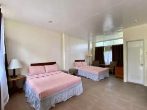 two beds in a room with pink sheets at Rio Vista Bed and Breakfast in Dagupan