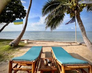 two chairs on a beach with the ocean at Three rare & private front beach villas in Thong Sala