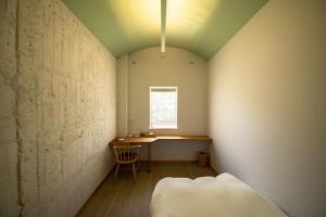 ein kleines Zimmer mit einem Tisch und einem Stuhl in der Unterkunft Megurimegurasu in Goto