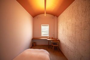 ein kleines Zimmer mit einem Tisch und einem Fenster in der Unterkunft Megurimegurasu in Goto