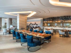 a restaurant with blue chairs and tables and a bar at Novotel Phuket City Phokeethra in Phuket Town