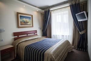 a hotel room with a bed and a window at Druzhba Hotel in Kryvyi Rih +43 photos