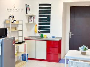 een keuken met rode en witte kasten en een deur bij Blue Studio Suite 1-4pax B'Worth Prai@SwimmingPool in Perai