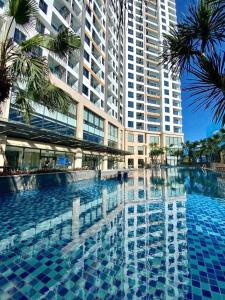 a swimming pool in front of a tall building at Mon Sapphire Homestay * View Sea and Poem Mountain in Ha Long