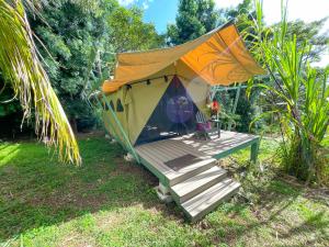 une tente avec une terrasse couverte en bois dans une cour dans l'établissement Gingerhill Farm Retreat, à Kealakekua