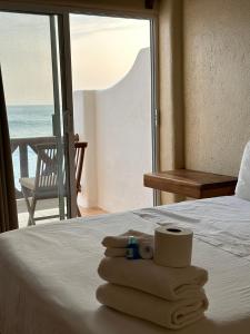 a hotel room with a bed with towels and a window at Hotel Estrella de Mar in Zipolite