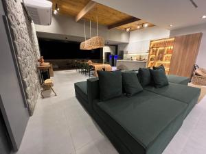 ein Wohnzimmer mit einem grünen Sofa und einem Esszimmer in der Unterkunft Kanui Mar (cobertura garden) in São Miguel dos Milagres