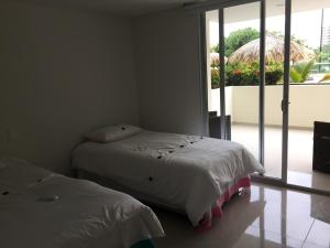 a bedroom with two beds and a large window at Apartamento Santa Marta Bello Horizonte - Pozos Colorados in Santa Marta