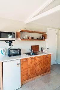 a kitchen with a sink and a microwave at The Hen House in Kaipara Flats
