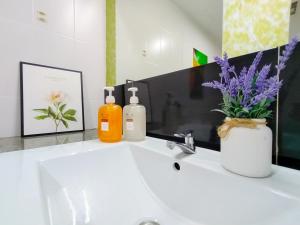 lavabo con 2 botellas de jabón y flores en Fahrenheit 88 Bukit Bintang By Manhattan Group, en Kuala Lumpur