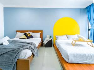 een slaapkamer met 2 bedden en een gele en blauwe muur bij Fahrenheit 88 Bukit Bintang By Manhattan Group in Kuala Lumpur
