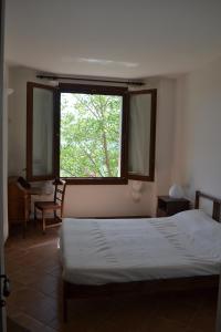 a bedroom with a bed and a large window at B&B Cà Biocco in Sogliano al Rubicone