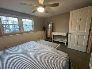 a bedroom with a bed and a ceiling fan at Ocean Breeze-8min Walk to Beach in Gloucester