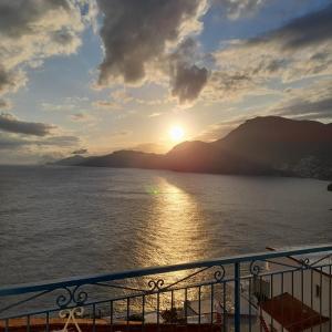 a view of the sun setting over the water at Panoramic Sea View Balcony Apartment in the Heart of Praiano, Casa Mimì Junior in Praiano