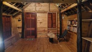 an empty room with a chair in a wooden cabin at KONKE RUỘNG FARMSTAY in Kon Von Kla