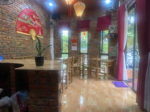 a room with tables and chairs and a brick wall at Sunshine villa thuy bieu in Hue