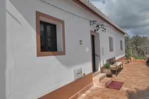 einen seitlichen Blick auf ein weißes Gebäude mit einer Terrasse in der Unterkunft Casa Alegria in Sabóia