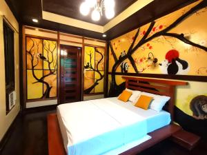 - une chambre avec un lit orné d'une peinture murale dans l'établissement Forest wood-Port Barton, à San Vicente