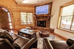 a living room with a couch and a fireplace at Bel Air of Big Bear - Fun & Tech & Massive Cabin in Big Bear City
