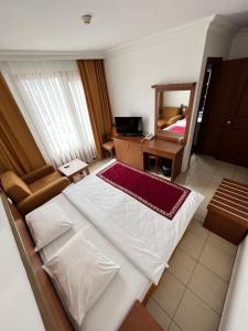 - une chambre avec un lit blanc et un miroir dans l'établissement Hotel Royal Hill, à Antalya
