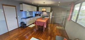 a kitchen with a table in the middle of a room at Spacieux et charmant Appartement Heremata - Arue - Tahiti in Arue
