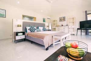 a bedroom with a bed and a table with a bowl of fruit at Denika's Suites in Puerto Princesa City
