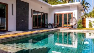 a swimming pool in front of a house at Ozzy villa phangan in Wok Tum