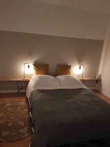 a bedroom with a large bed with two lamps on it at maison de vacances locquirec in Locquirec