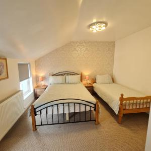 a bedroom with two beds and two lamps in it at Ulverston Town Centre Flat (2 Bedrooms) in Ulverston