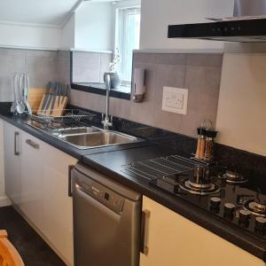a kitchen with a sink and a stove at Ulverston Town Centre Flat (2 Bedrooms) in Ulverston
