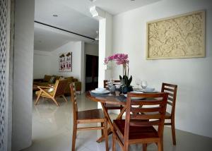 a dining room with a wooden table and chairs at Villa Majegau 1 by Deasha in Seminyak