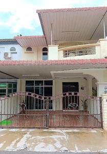 una casa con portico in legno e recinzione di HELLO HOMESTAY a Nibung Tebal