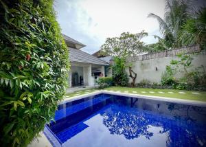 a swimming pool in front of a house at Villa Majegau 1 by Deasha in Seminyak