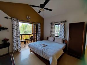 ein Schlafzimmer mit einem Bett und einem großen Fenster in der Unterkunft Ronne's 2BHK Lagoon Apartment -Calangute in Calangute