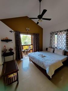 Schlafzimmer mit einem großen Bett und einem Deckenventilator in der Unterkunft Ronne's 2BHK Lagoon Apartment -Calangute in Calangute