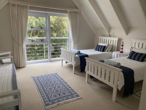 Un dormitorio con dos camas y una gran ventana. en Crystal Waters, St Francis Bay, Eastern Cape, en St Francis Bay
