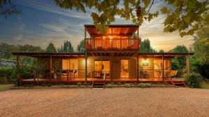 a house with a wrap around porch with a deck at Beechworth Cedar Cottages in Beechworth