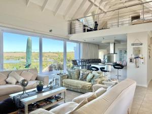 Una sala de estar con sofás y una gran ventana. en Crystal Waters, St Francis Bay, Eastern Cape, en St Francis Bay