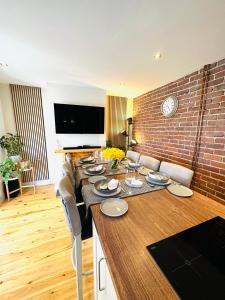a room with a long table with chairs and a brick wall at Dolwen Snowdonia Home by PolkaDot in Caernarfon