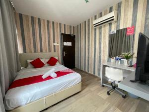 Dormitorio con cama, escritorio y TV en City Kuchai Hotel -Kuchai Lama,Kuala Lumpur, en Kuala Lumpur